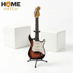 Mini electric guitar decoration showpiece with stand on white background front view