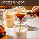 Multi-purpose glass server with wooden handle, used for coffee, milk, sauces, salad dressings, and condiments.