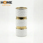 White textured ceramic vase with gold metallic accents on a clean background