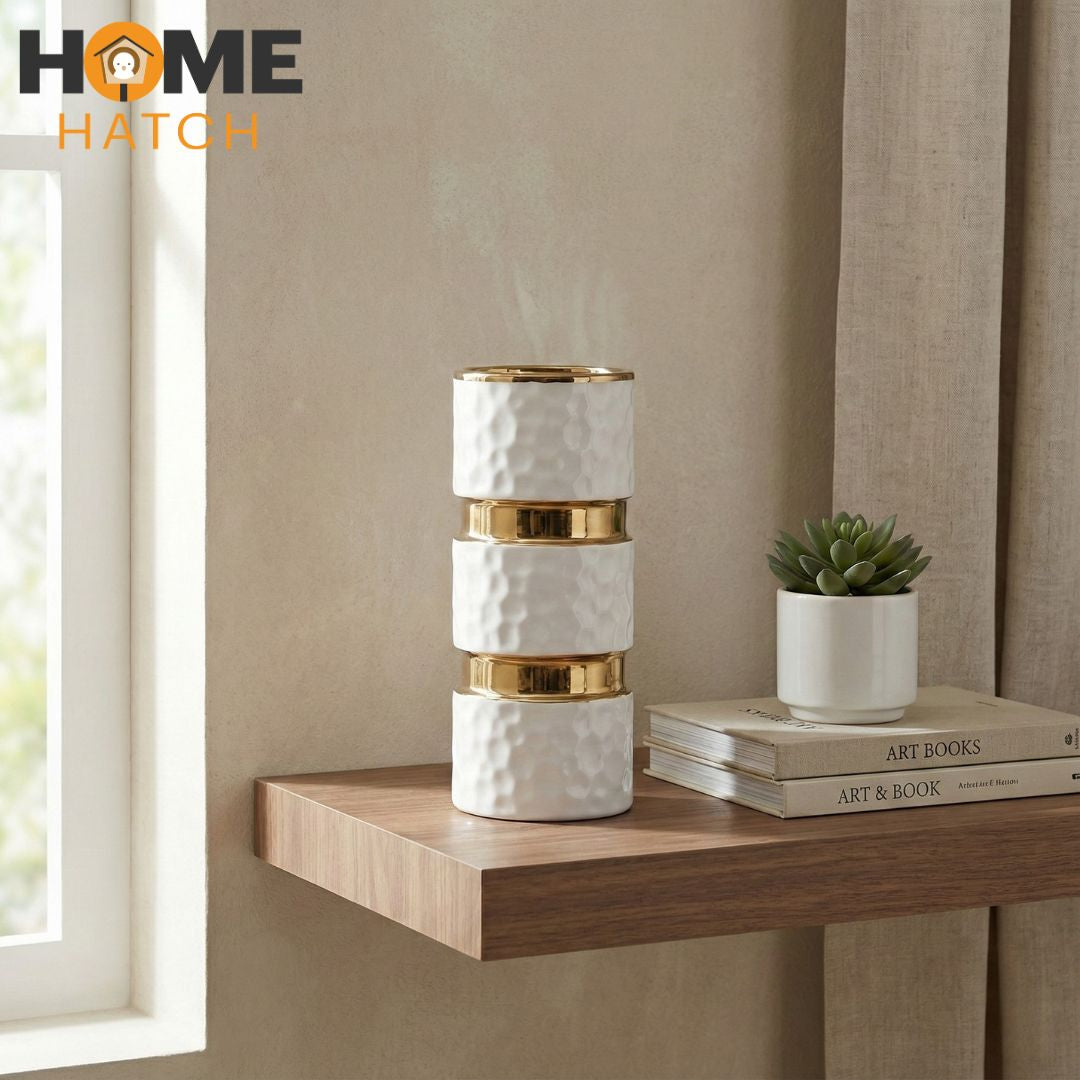 White textured ceramic vase with gold metallic accents on a clean background
